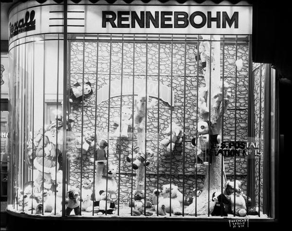 The window of Rennebohm's Drugstore #2, 204 State Street, displaying Santa Claus and an array of stuffed animal toys, mainly Teddy bears. A sign on the display reads: "Santa's Zoo." The sign painted on the window on the right reads: "U.S. Postal Station No. 15."