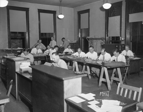 Group of 14 volunteers at the Dane County Gas Ration Board to assist with wartime gas rationing, alternate view.