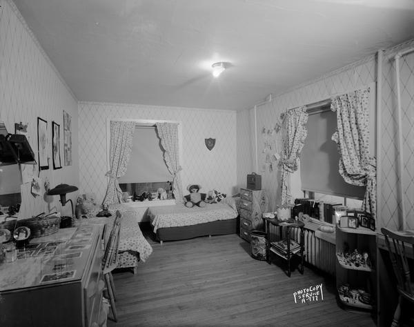 Typical college girl's bedroom with frilly curtains, knick-knacks on shelves, and stuffed animals on the bed at the Victoria House, 225 Lake Lawn Place.