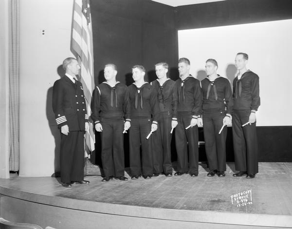 Commander Leslie K. Pollard and six honor students from the U.S. Naval Training School (Radio), Division #40, University of Wisconsin-Madison, posing for a group portrait.