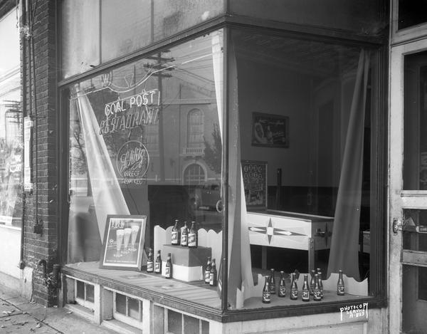 Storefront of Goal Post Restaurant and Tavern, 1515 Monroe Street, display window featuring bottles of Schlitz beer and 7-UP with a pinball machine visible through the window.