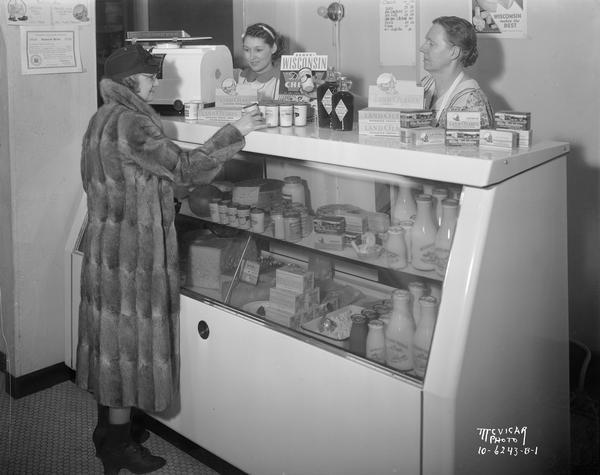 Two clerks and a customer in McCoy's Ice Cream Shop, 507 State Street, with Oscar Mayer Coolerator food display case.