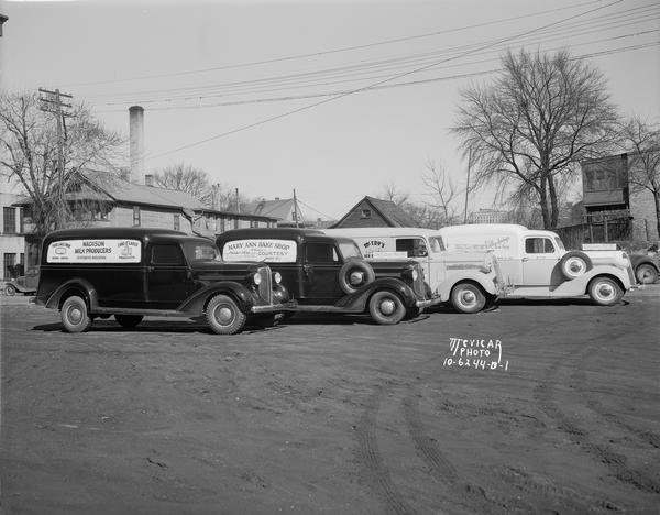 Four panel trucks, one each with the following names painted on the sides: Madison Milk Producers, Mary Ann Bake Shop, McCoy's Ice Cream, Valley Springs Farm Dairy, parked on S. Bedford Street near Motor Sales Co., 555 West Washington Avenue.
