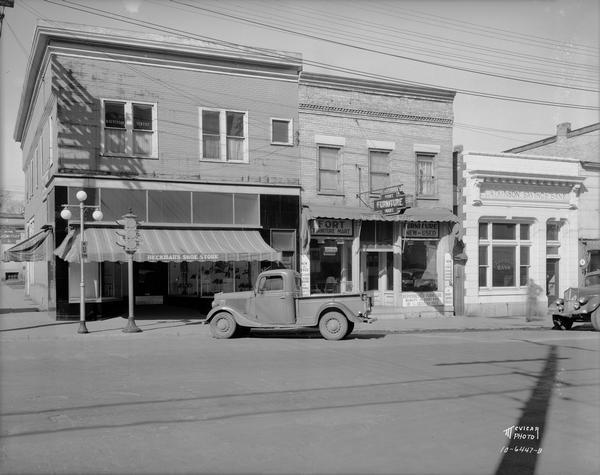 Fort Atkinson street scene, looking across street towards a truck parked in front of Beckman's Shoe Store. Next to Beckman's is Fort Furniture Mart and Fort Atkinson Savings Bank.