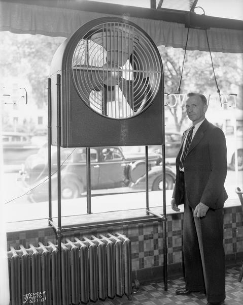 Man standing next to new fan at Lawrence Lunch, 662-664 State Street.