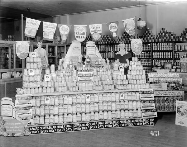 Frank Bros. grocery store located at 609-613 University Avenue with a Kraft Salad Week display. Large display of Miracle Whip, mayonnaise and other salad dressings. It also includes a small cheese display and two women cut-outs holding trays.