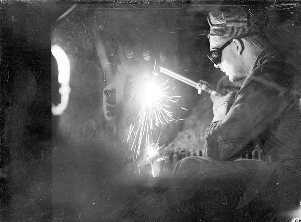 Howard Sechrest, of Howard Welding & Machine Co., wears goggles and welds in the boiler at the Loraine Hotel.