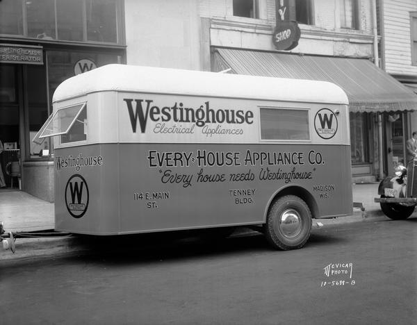 Every-House Appliance Co. trailer with a sign that reads: "Every house needs Westinghouse," 114 E. Main Street.
