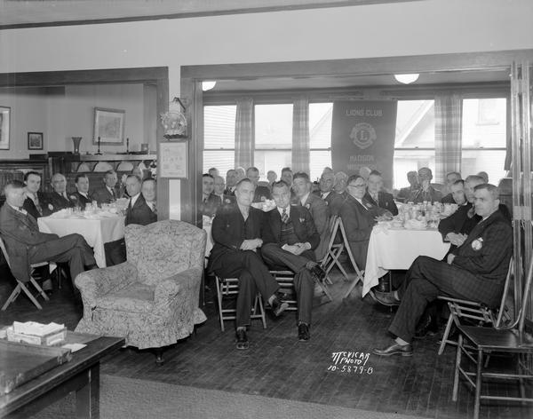 Group portrait of Lions Club members seated around tables in the Neighborhood House, 768 W. Washington Avenue.
