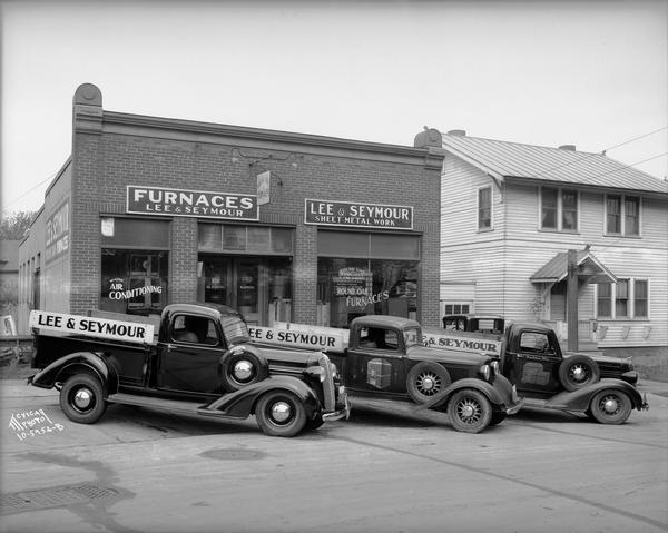 Three Lee & Seymour delivery trucks parked in front of Lee & Seymour Furnace and Sheet Metal Co., 346 Russell Street.
