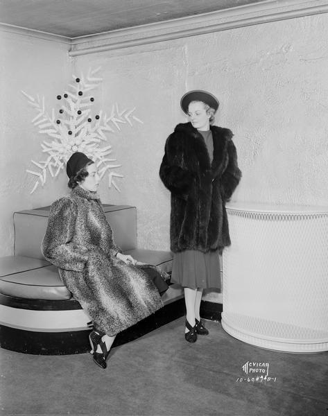 Two women modeling fur coats for Simpson's women's clothing store, 23 N. Pinckney Street.