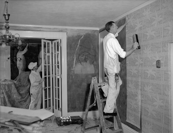 Three Klein-Dickert paperhangers and painters at work in a house.