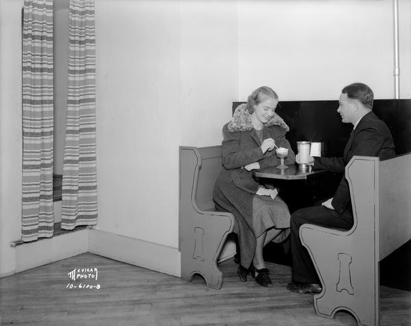 Couple sitting in a booth and eating ice cream in booth at McCoy's Ice Cream Parlor, 507 State Street.