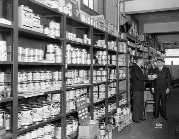 A sales clerk assists a customer in the Mautz paint department at Price Hardware Store, 626 S. Park Street.