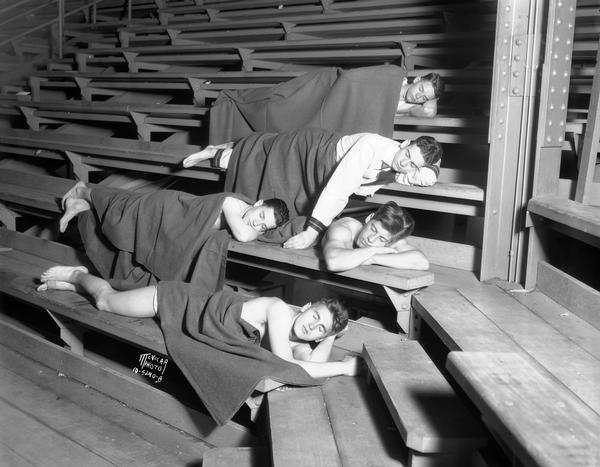 A group of high school musicians, from East Waterloo (Iowa?) High School, sleeping on bleachers in the Field House during a National School Music contest.