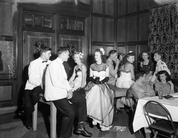 Couples enjoy the "Moonlight Formal" in Tripp Commons, University of Wisconsin Memorial Union. They are in formal dress with some of the men in military uniforms.