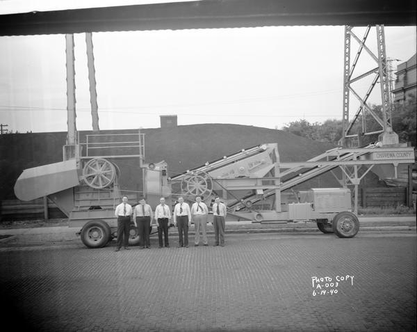 Men posing in front of a rock crusher manufactured by Wisconsin Foundry & Machine Company, 623 East Main Street.