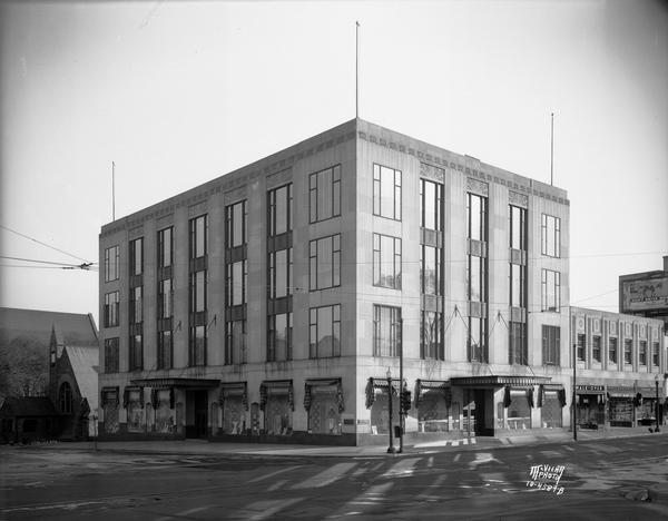 Harry S. Manchesters Inc. Department Store, 2-6 E. Mifflin Street, and other businesses: Walk-Over Shoes, 8 E. Mifflin Street, Moseley's Books, 10 E. Mifflin Street, and the Unitarian Society Meeting House on the left, 125 Wisconsin Avenue.
