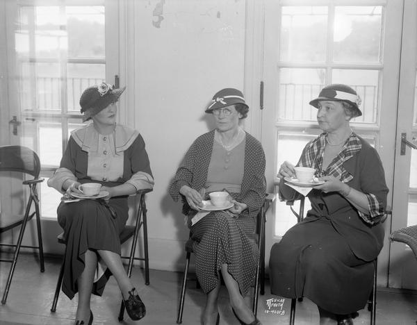 Maple Bluff Country Club afternoon tea. Left to right: Mrs. John Stephan, Mrs. J.E. O'Connell, and Mrs. Theodore Lewis, President of the women's organization.