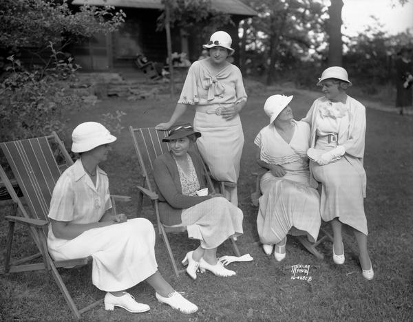 Women relax on the lawn at Bungalowen, the home of Professor Ray and Mrs. Theo Owen in Frost Woods, at 5805-7 Winnequah Road. Left to right: Mrs. Ira L. Baldwin; Mrs. George S. Bryan; Mrs. C.J. Anderson; Mrs. Asher Hobson; and Mrs. Andrew Weaver, all University League board members.