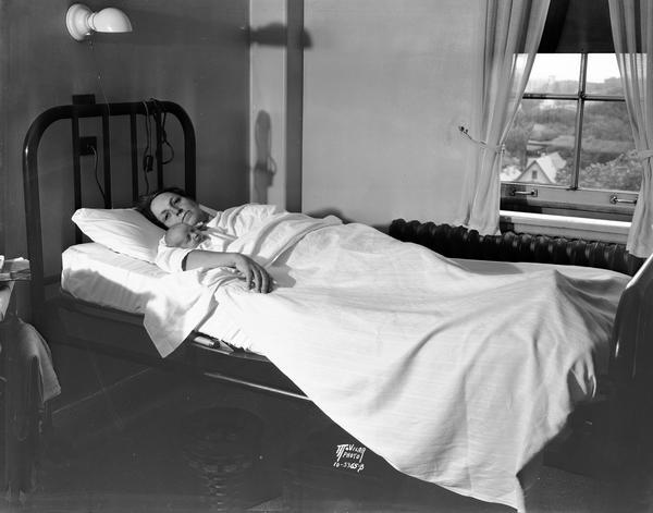 Clara Halvorson, married to Henry Halvorson, resting with her 17th child, John Skews Halvorson, at Methodist Hospital shortly after the baby's birth. She was 46 years old at this time.