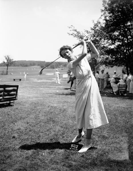 Portrait of Dorothy Page, who is demonstrating her golf swing on the golf course.