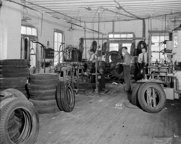 Two men retreading tires at Edwards Tire Company, located at 124 W. Main Street.