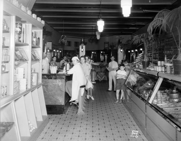 Julius Giller, proprietor at Julian's Delicatessen and Sandwich Shop at 226 State Street, with customers.
