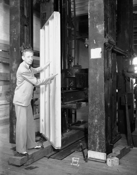 U.S. Forest Products engineer, George W. Trayer, in the laboratory with a plywood panel, newly developed to provide strength and durability in construction.