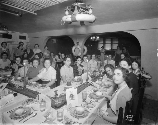 Alpha Epsilon Phi sorority women, seated at tables decorated with a marine theme, for an informal senior group finishing dinner at 135 Langdon Street.