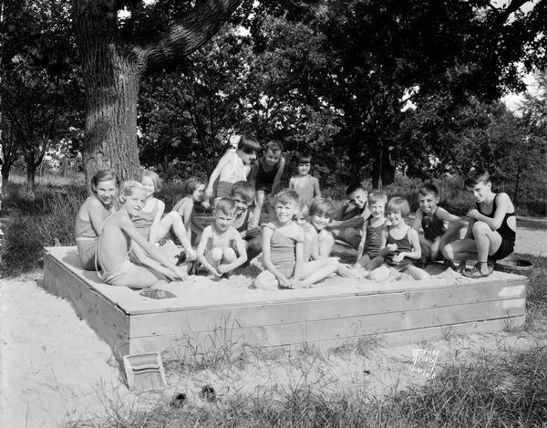 A large group of children plays in a sandbox at The Capital Times Kiddie Camp.