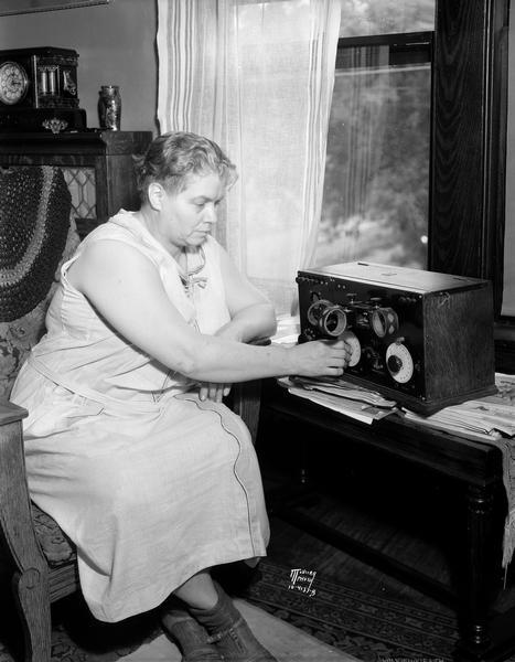 Melvina (Mrs. Samuel) Capron, 222 N. Bassett Street, listening to a radio and reenacting the night in 1923 when she heard that President Warren G. Harding had died.