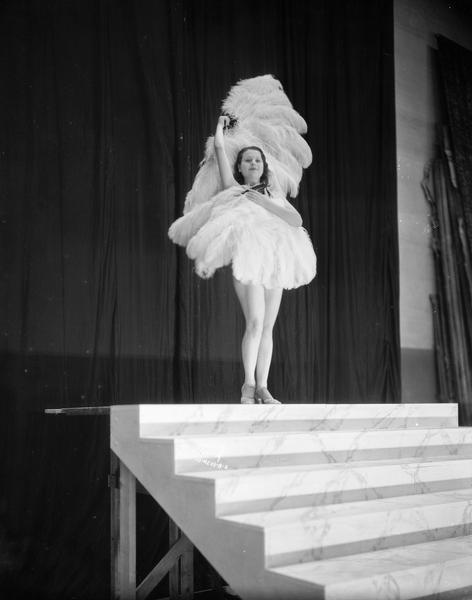 Rosita Carmen, burlesque dancer, performing with feather fans on the stage of the Orpheum Theatre.