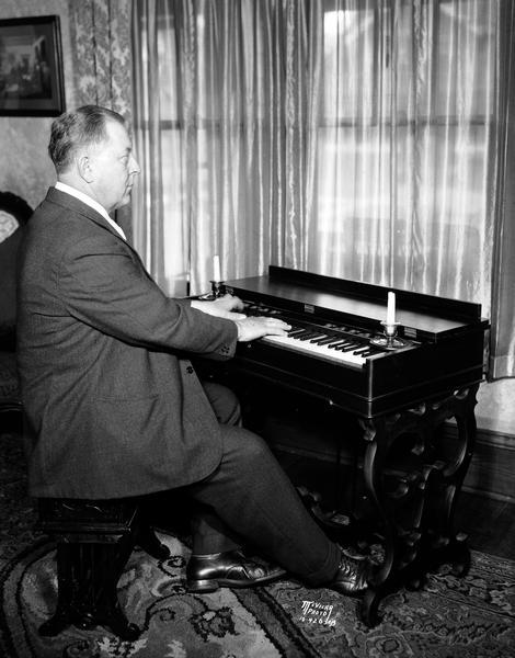 George J. Friedrich, floor manager at the Burdick & Murray Co., playing a Melodian at the Bullard house, 1154 E. Mifflin Street.