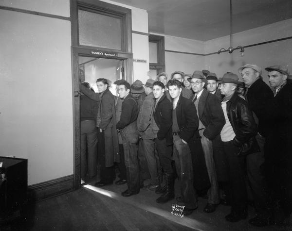 Unemployed men stand in line for CWA (Civil Works Administration) jobs, inside the Public Employment Office, 111 W. Main Street.