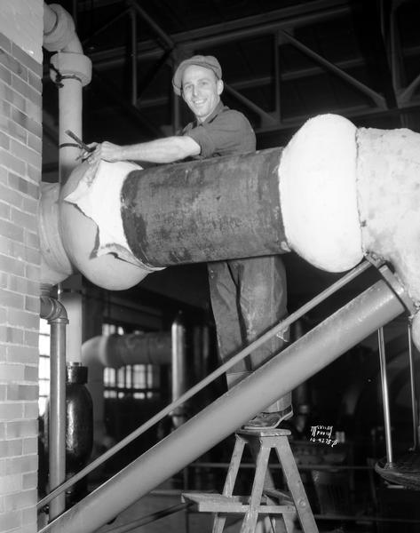 John Hines dismantling one of two out-of-date pumps at the Madison Water Works, 311 N. Hancock Street, a job he obtained through the CWA (Civil Works Administration).