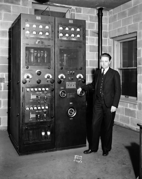 Everett H. Marshall stands next to a radio transmitter at the WIBA transmitter station, 111 King Street.