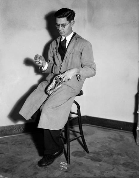 Mr. S. Schafer in laboratory coat, holding one large and one small snake.