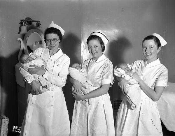 Three baby girls were born on President Franklin Roosevelt's birthday; Beverly Ann Shepherd, held by nurse Bernice Schantz, Marilyn Joan Hauden, held by nurse Ruth Peck, and Baby Smith, daughter of Mr. and Mrs. Albert Smith, held by Eleanor Tandvig.