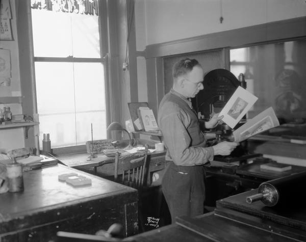 At the Wisconsin Engraving Co., 109 S. Carroll Street, as part of the finishing and proofing process, a worker is checking a halftone flat against the copy for final fine etching to give added brilliance to highlights.