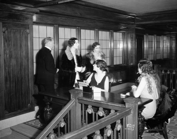 Two women greet guests at the registration table for the Attic Angels Ball in the Loraine Hotel.