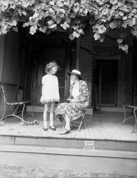 Portrait of Mrs. Burton K. Wheeler and daughter, Marion Montana Wheeler, of Butte Montana, on the porch of the La Follette farmhouse. In 1924 Robert M. La Follette selected Senator Wheeler as the vice-presidential candidate for his independent, third-party run for the Presidency.
