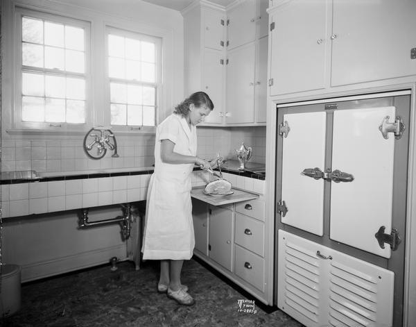 A woman slicing ham in the Oscar Mayer kitchen.
