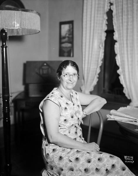 Portrait of Mrs. F.G. Ives, employee of Stoughton Bank, posing at home.