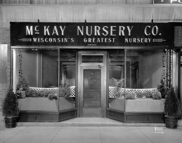Storefront of McKay Nursery, 911 University Avenue. The sign above the entrance reads: "McKay Nursery Co. Wisconsin's Greatest Nursery."