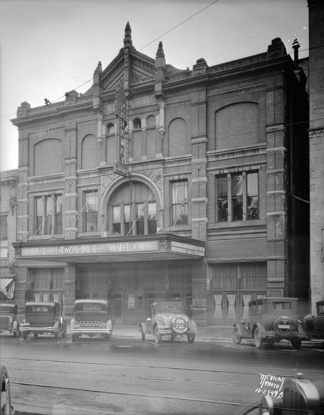 Exterior view of Parkway Theater (formerly Fuller Opera House). 6-10 W. Mifflin Street. McVicar's automobile is parked in front with a sign on the tire cover. The Fuller Opera House sign is at the roofline.