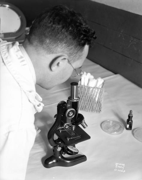A food scientist looking through a microscope at Oscar Mayer.