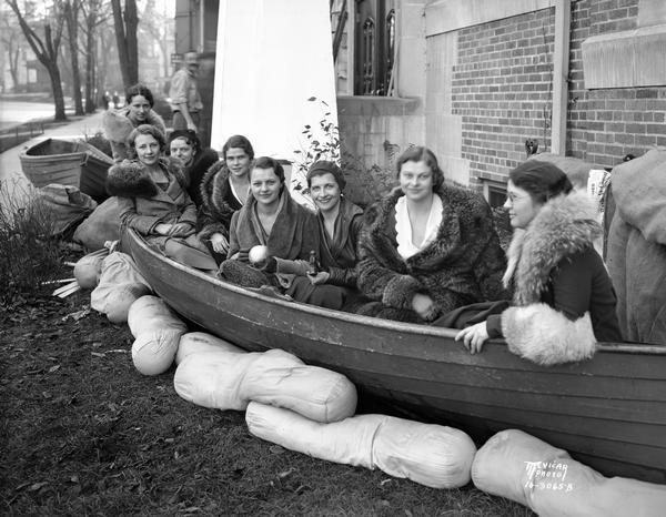 University of Wisconsin coeds sitting in a boat surrounded by sand bags in front of Ann Emery Hall, 265 Langdon Street, an independent women's dormitory. It was named for the first Dean of Women (1897-1900) Ann Emery Allinson (1871-1932).