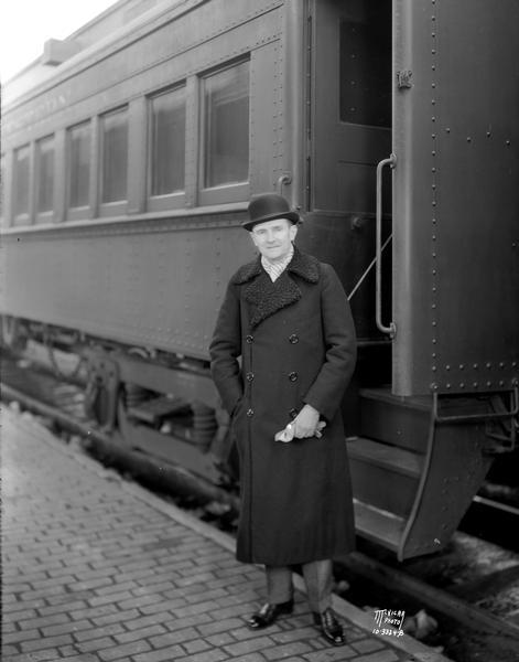German Ambassador to the United States, Baron Friedrich Von Prittwitz und Gaffron, standing outdoors next to a railroad passenger train car.