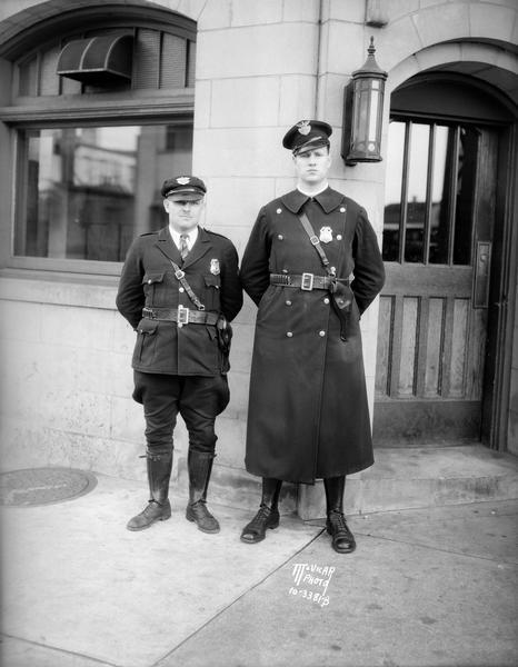 Portrait of Police Officer Earl V. Bonner, the shortest man on the Madison police force, who joined in 1928, and Romain W. York Jr., the tallest man on the Madison police force, who joined in 1925.